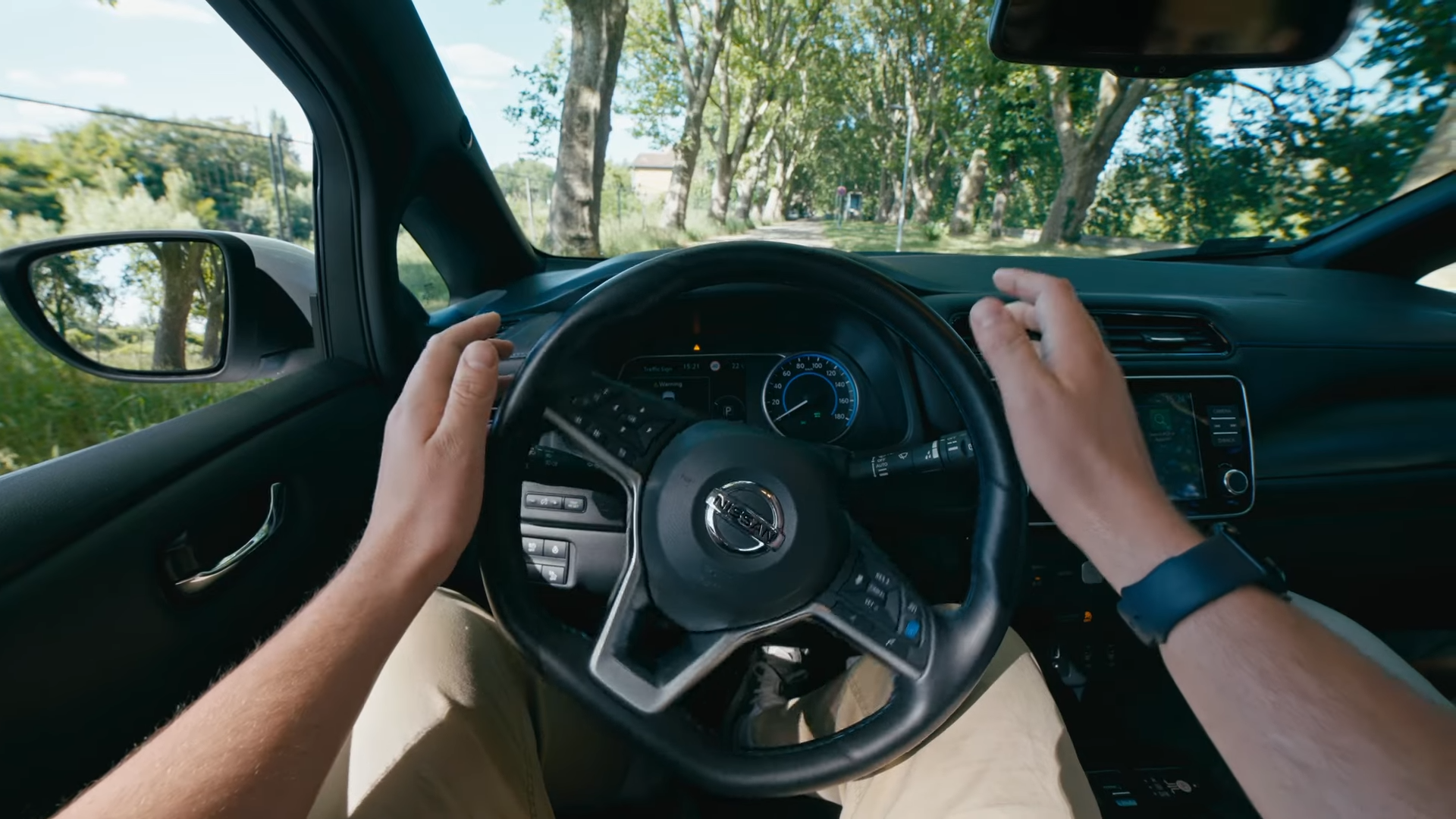 A driver seat perspective of a steering wheel turning without the driver&#039;s direct control.